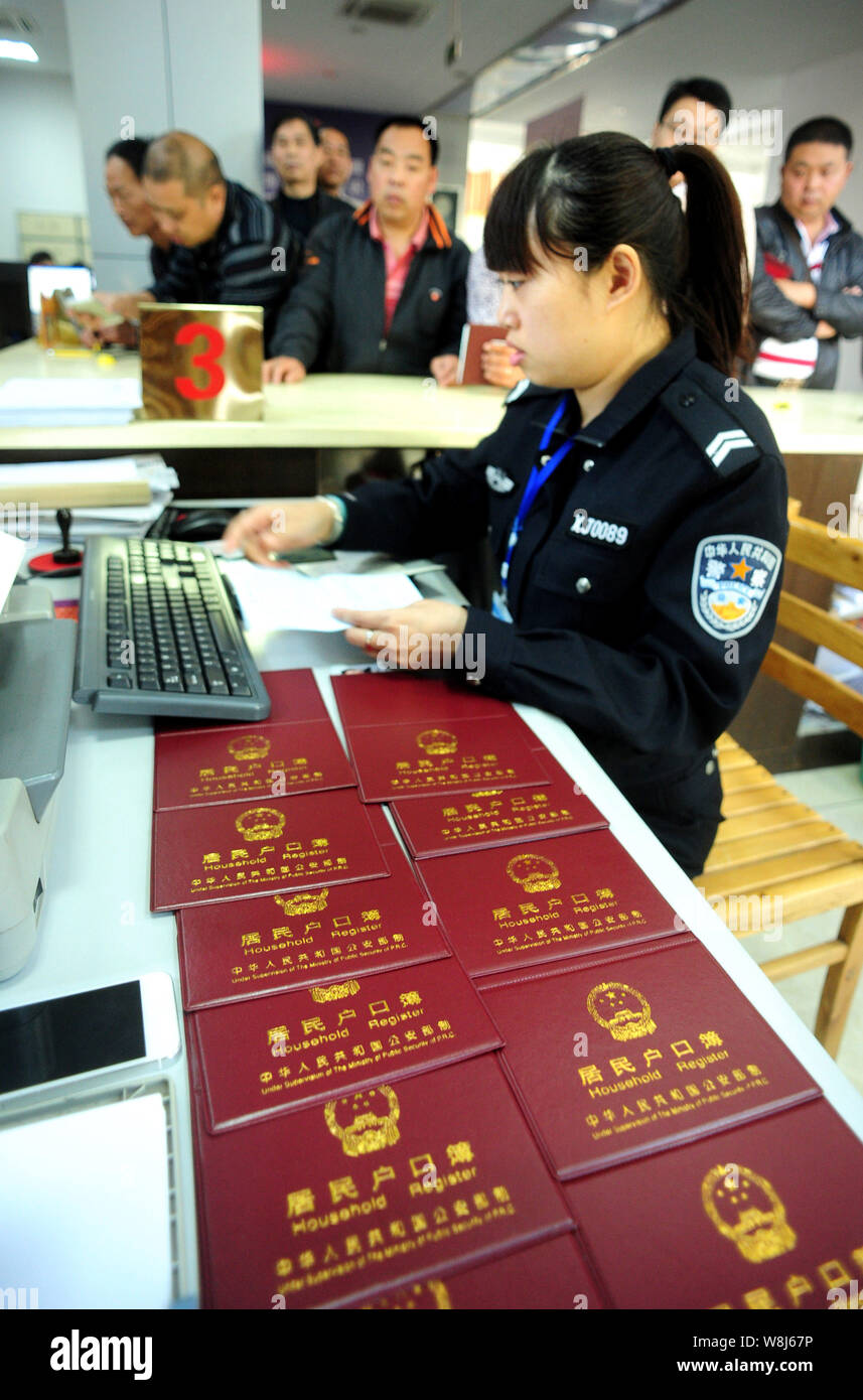 ---- Eine weibliche chinesische Polizisten befasst sich mit Anmeldung und Fragen Haushalte registriert, auch als hukou bekannt, für die lokalen Bewohner an Stockfoto