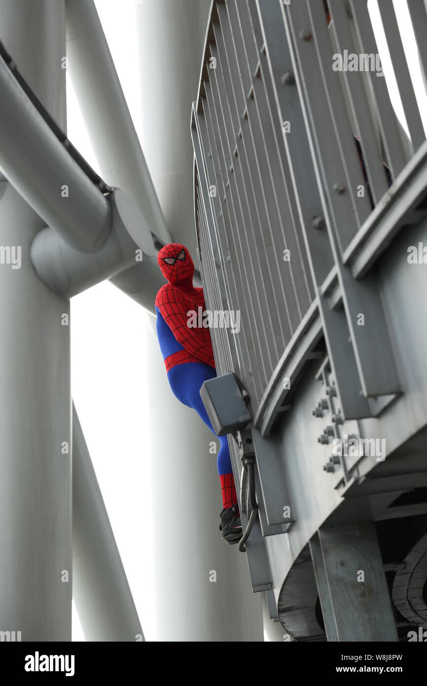 Ein Mann, gekleidet in der Spider-man Kostüm klettert die Canton Tower zu seiner Freundin in der Stadt Guangzhou vorzuschlagen, die südchinesische Provinz Guangdong, 2 Stockfoto