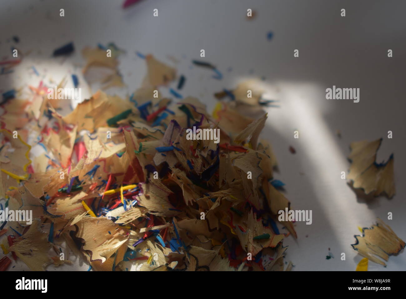 Multi-Buntstift Späne auf eine weiß/grauer Hintergrund mit natürlichem Licht durchscheinen. Stockfoto