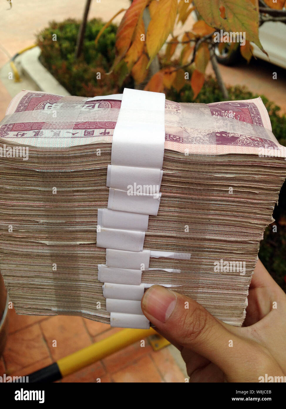 Eine chinesische Verkäufer der eine Wohn- Projekt zeigt Bündel von 50 Cent RMB (Renminbi) Banknoten, Teil der 400.000 yuan niedriger Stückelung Münze Stockfoto