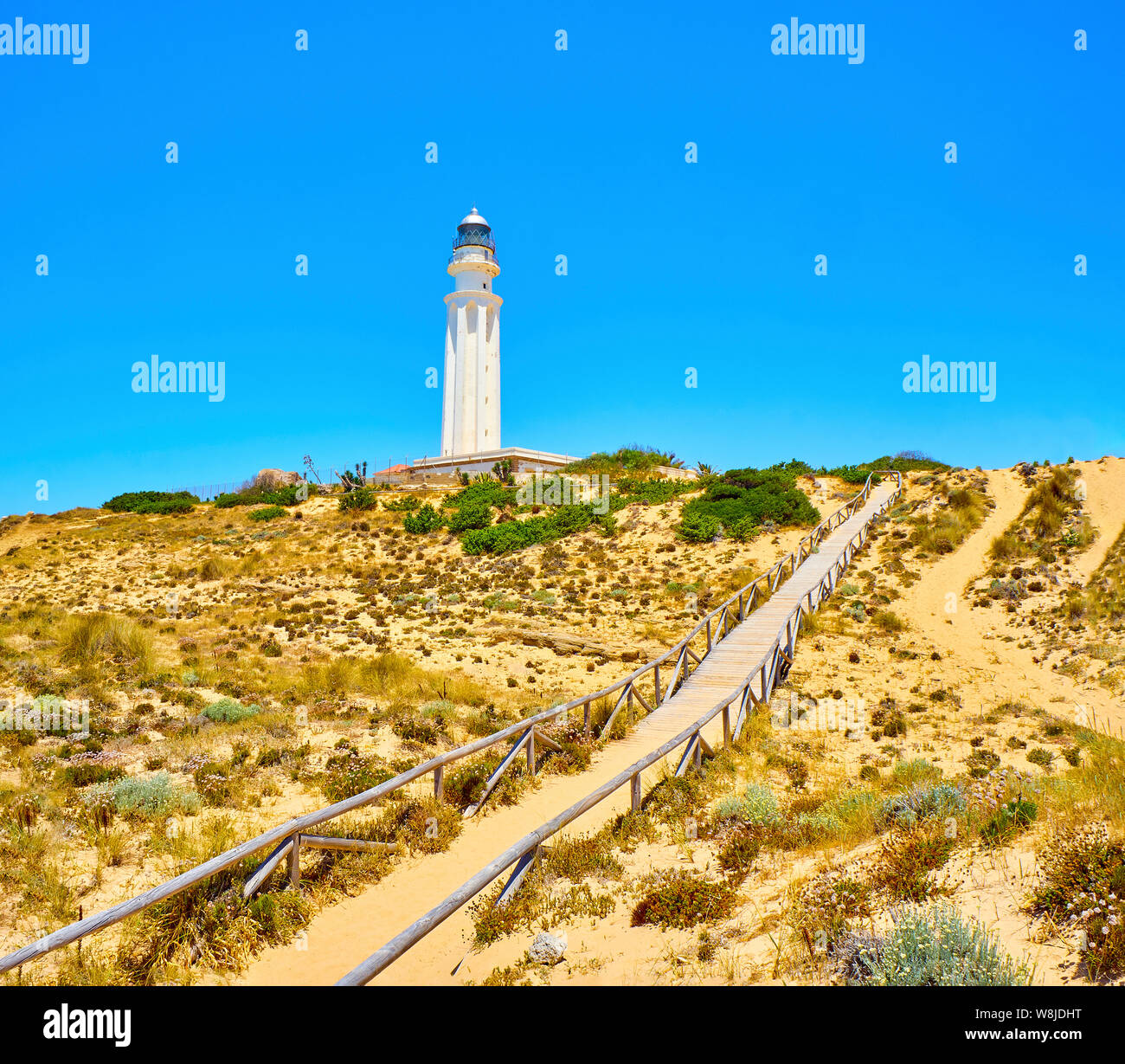 Holzsteg zum Faro de Trafalgar Leuchtturm, in Cabo de Trafalgar Kap Naturpark. Barbate, Conil de la Frontera, Cadiz. Andalusien, Spanien. Stockfoto