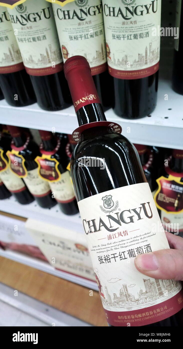 ---- Ein Kunde Geschäfte für eine Flasche Changyu trockener Rotwein in einem Supermarkt in Shanghai, China, 1. Mai 2013. Yantai Changyu Pioneer Wine Company L Stockfoto