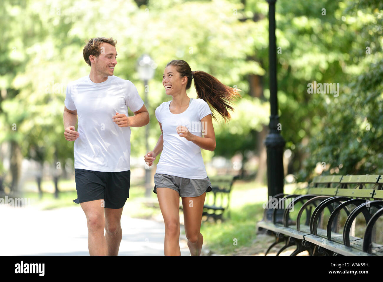 Läufer joggen zusammen in New York City der Central Park, USA. Gesundes Paar von New Yorkern Athleten Freunde läuft im Sommer Sonne ein cardio übung auf Manhattan, Vereinigten Staaten von Amerika. Stockfoto