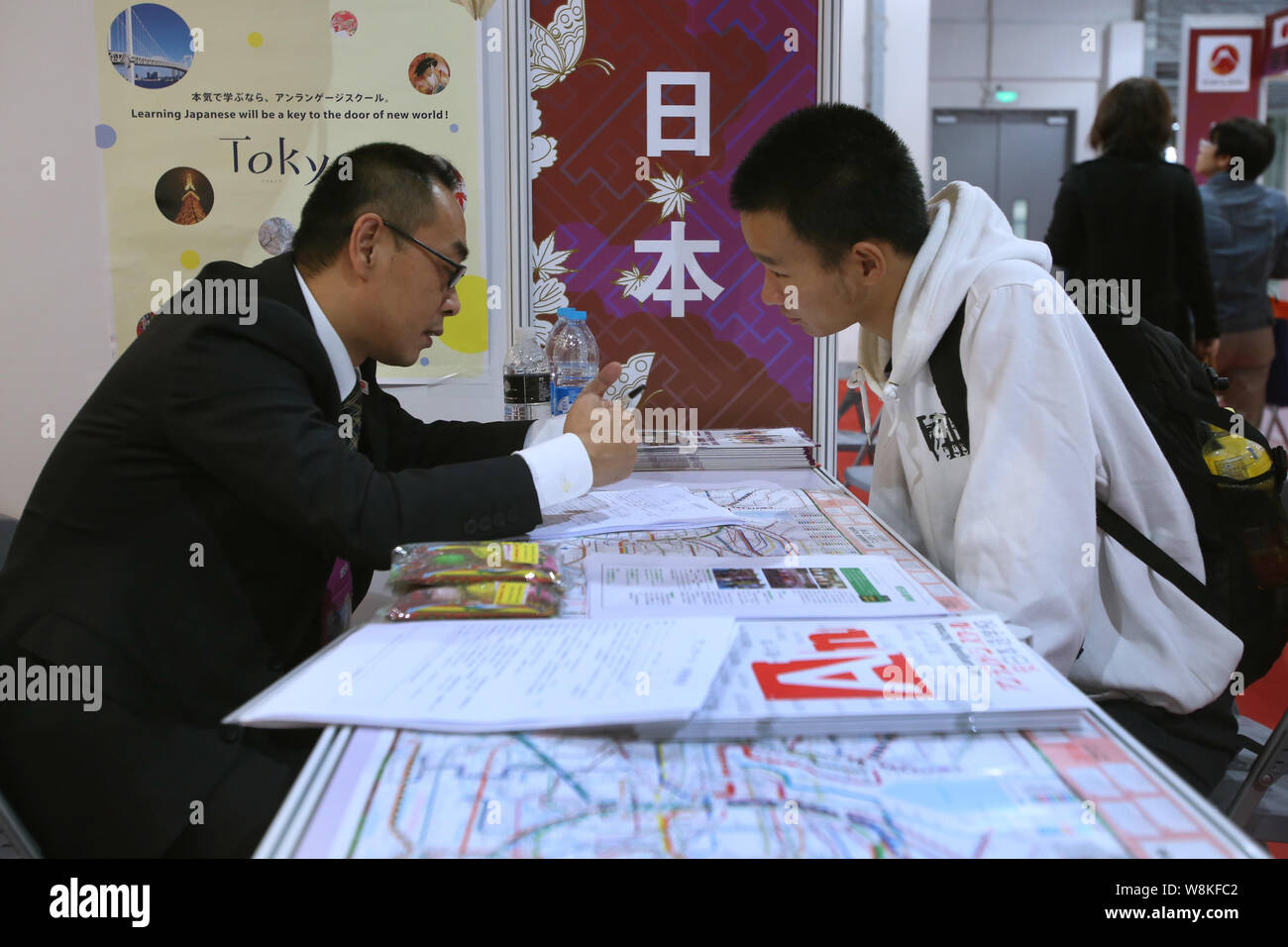 ---- Eine Ausbildung Berater aus Japan, Links, Gespräche mit einem chinesischen Besucher auf einen Stand im Ausstellungsbereich für Japan während der China 2015 Educa Stockfoto