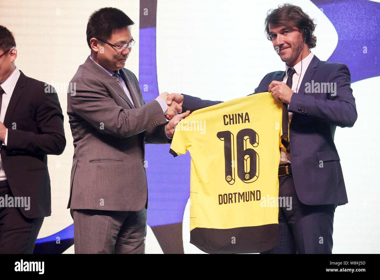 Borussia Dortmund der ehemaligen Deutschen Fußball-Star Karl-Heinz Riedle, rechts, schüttelt Hände mit einem anderen Gast auf einer Pressekonferenz für das China Spiel des Stockfoto