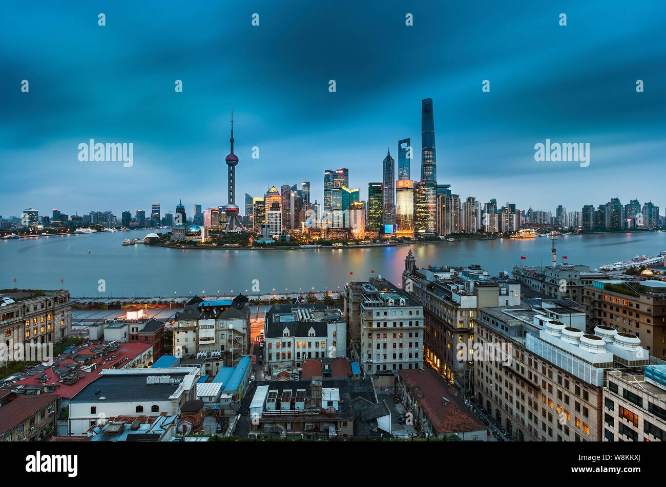 ---- Panorama Nacht Blick auf die Gebäude in der Nähe des Bund entlang des Huangpu-Flusses in Puxi und dem Finanzviertel Lujiazui mit dem Shanghai Tower, Stockfoto