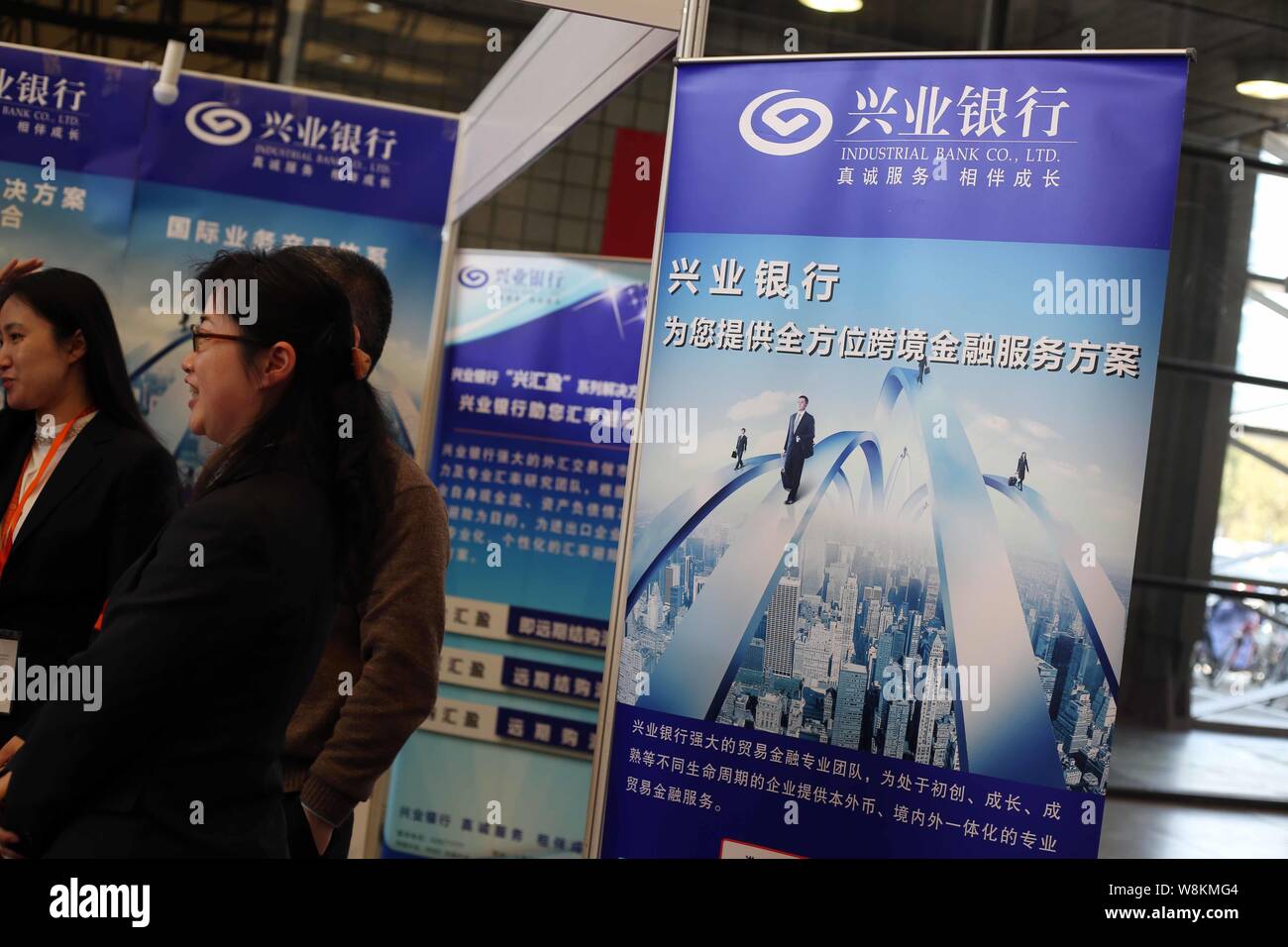 Chinesische Mitarbeiter sind am Stand der Industrial Bank Co., Ltd. während der 26 East China Import & Export Commodity Fair, auch bekannt als Osten Chi gesehen Stockfoto