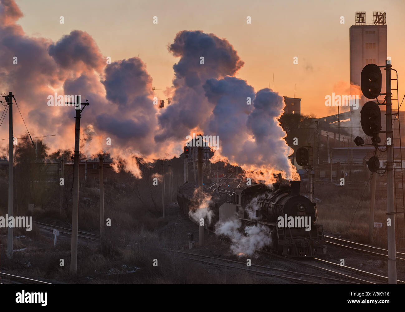 ---- Eine Dampflokomotive transportiert Kohle zu Wulong Coal Mine bei Sonnenuntergang in der Stadt Fuxin, im Nordosten der chinesischen Provinz Liaoning, 27. Januar 2015. China Stockfoto