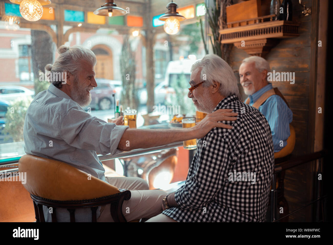 Drei pensionierte Männer in der Kneipe beim kühlen Bier trinken. Stockfoto