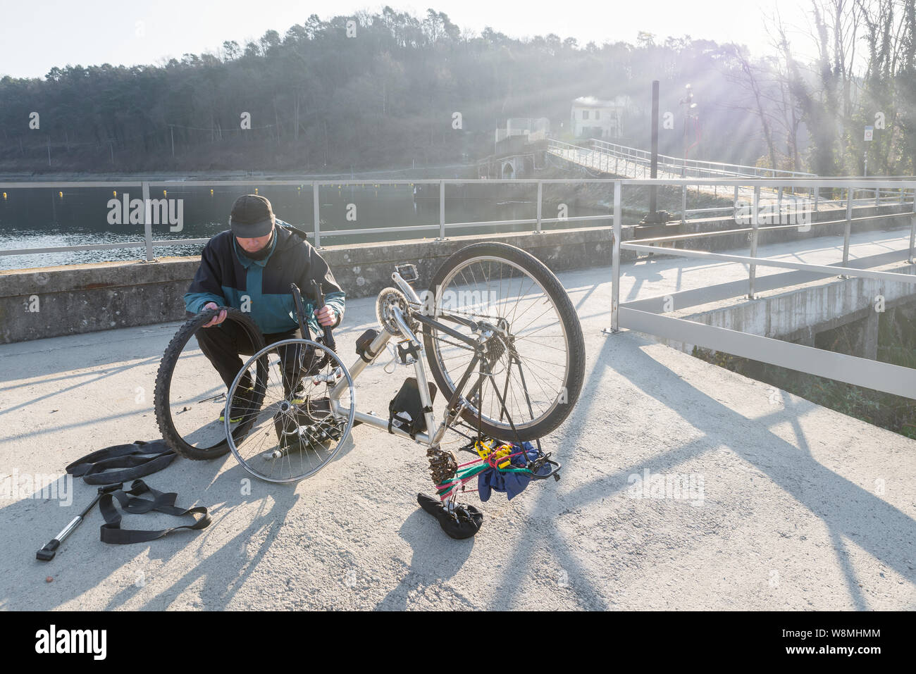 Man Radfahrer Reparaturen ein Fahrrad mit platten Reifen während einer Reise. Konzept der unvorhergesehenen und Pech Stockfoto
