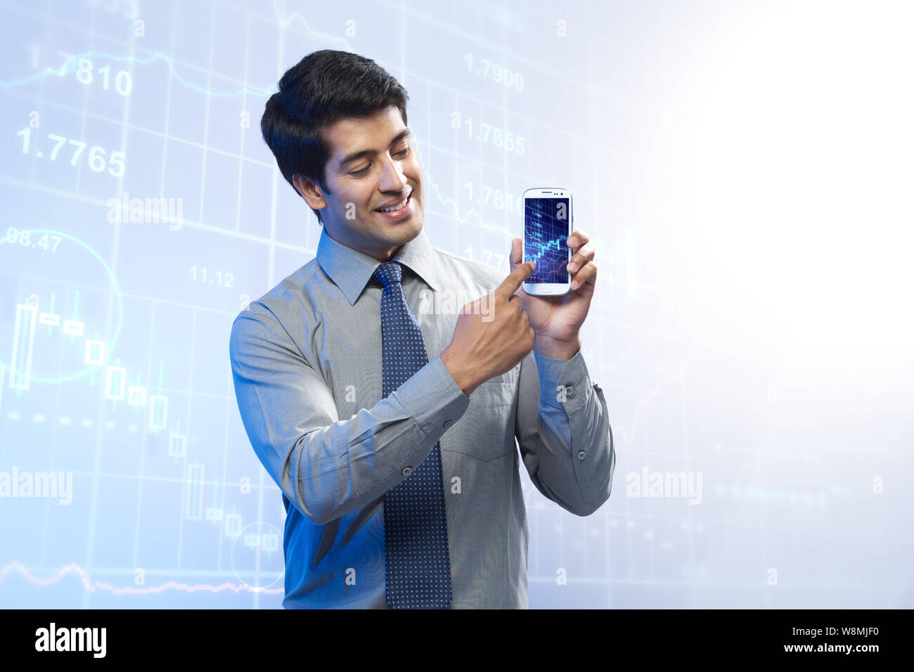 Geschäftsmann zeigt eine Grafik, die sich in einem Smartphone nach oben bewegt Stockfoto