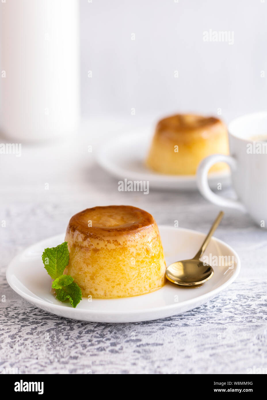 Creme Caramel Dessert oder Flan dekoriert mit Sahne und Minze. Süßer moment vertikale Hintergrund. Stockfoto