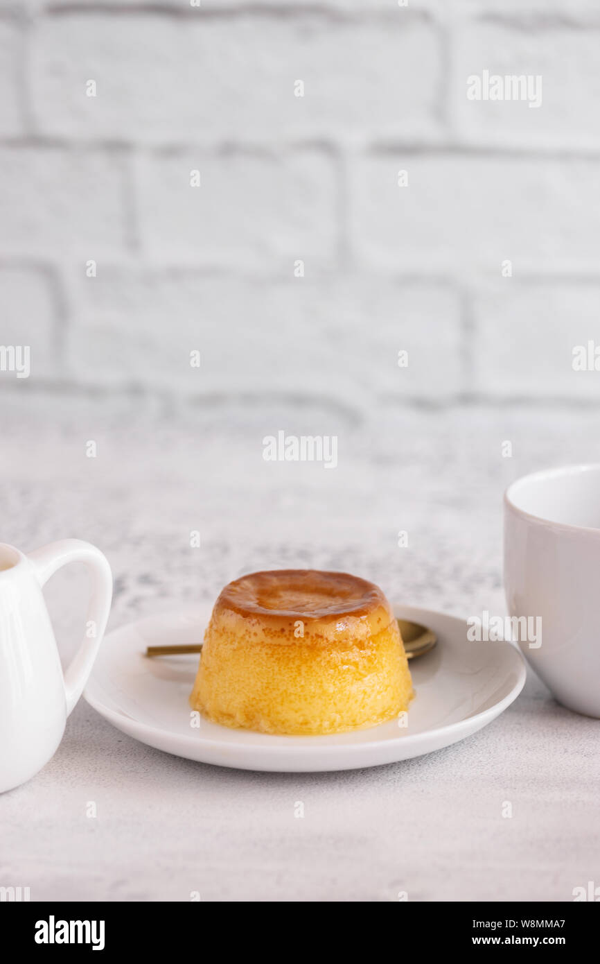 Creme Caramel Dessert oder Flan serviert mit Tasse Kaffee. Süßer moment vertikale Hintergrund. Stockfoto