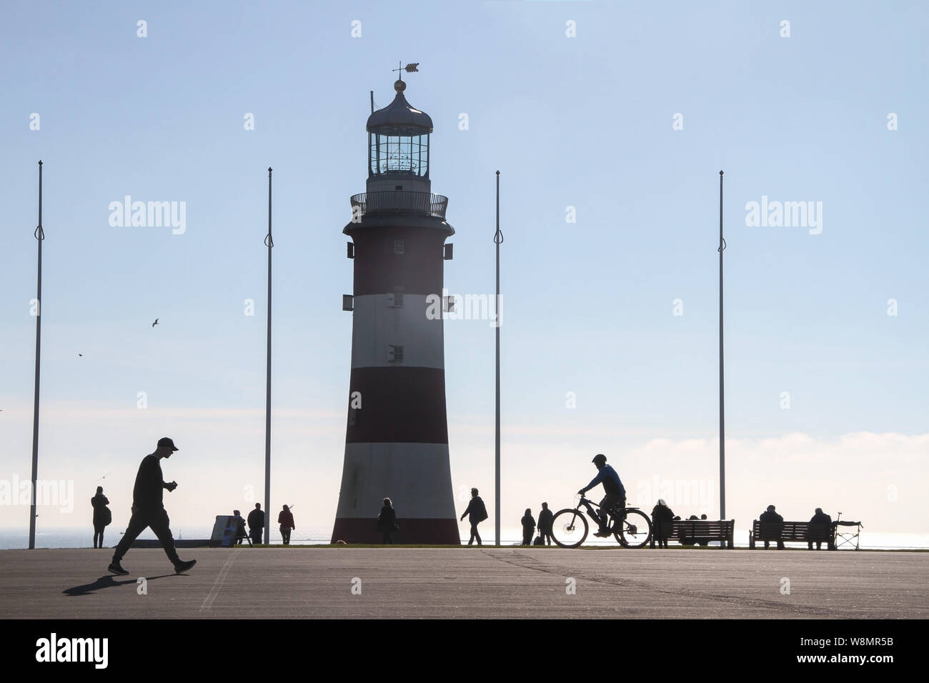 Smeaton's Tower auf Plymouth mit Silhouetten von Fußgängern, Besucher und ein Radfahrer Hoe, eine perfekte entscheidenden Moment Zusammensetzung Stockfoto