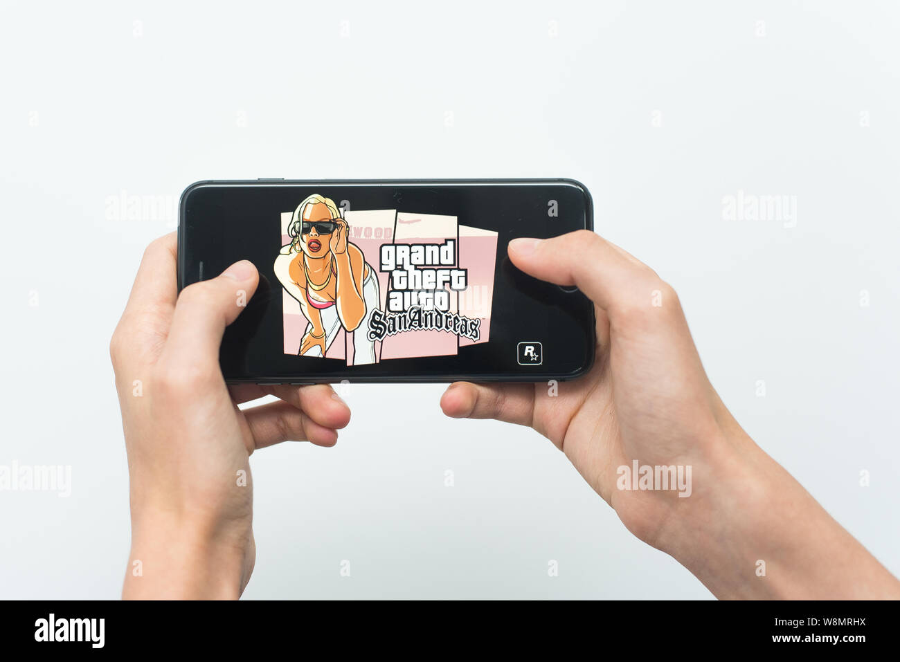 Samara, Russland-07, 29, 2019: ein junger Kerl spielen GTA-Spiel auf dem Iphone 8 Plus. Teenager hält ein Handy in der Hand mit einem Spiel Grand Theft Auto: Sa Stockfoto