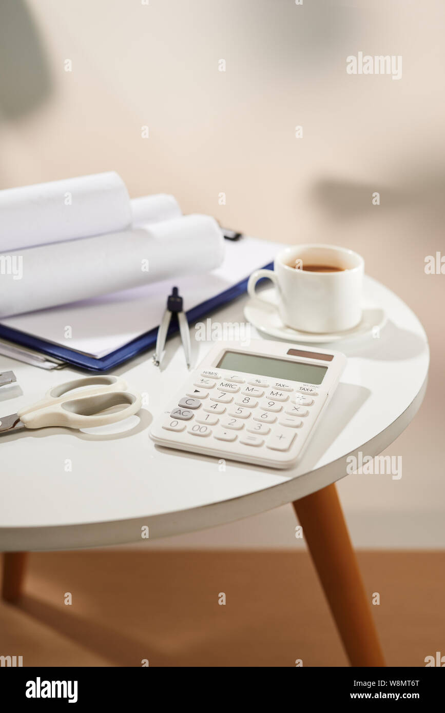 Blick von oben auf die Notebook, leere Seite, Rechner, Kaffeetasse, Scheren und Messer auf weißem Papier Stockfoto