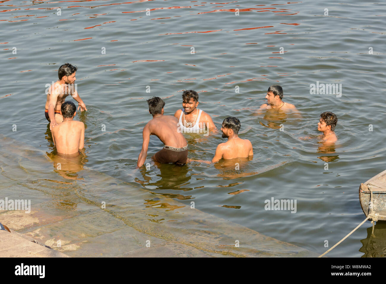 Eine Gruppe junger indischer Männer Baden im Fluss Ganges in Varanasi, Uttar Pradesh, Indien, Südasien. Auch als Benares, Banaras und Kashi bekannt. Stockfoto