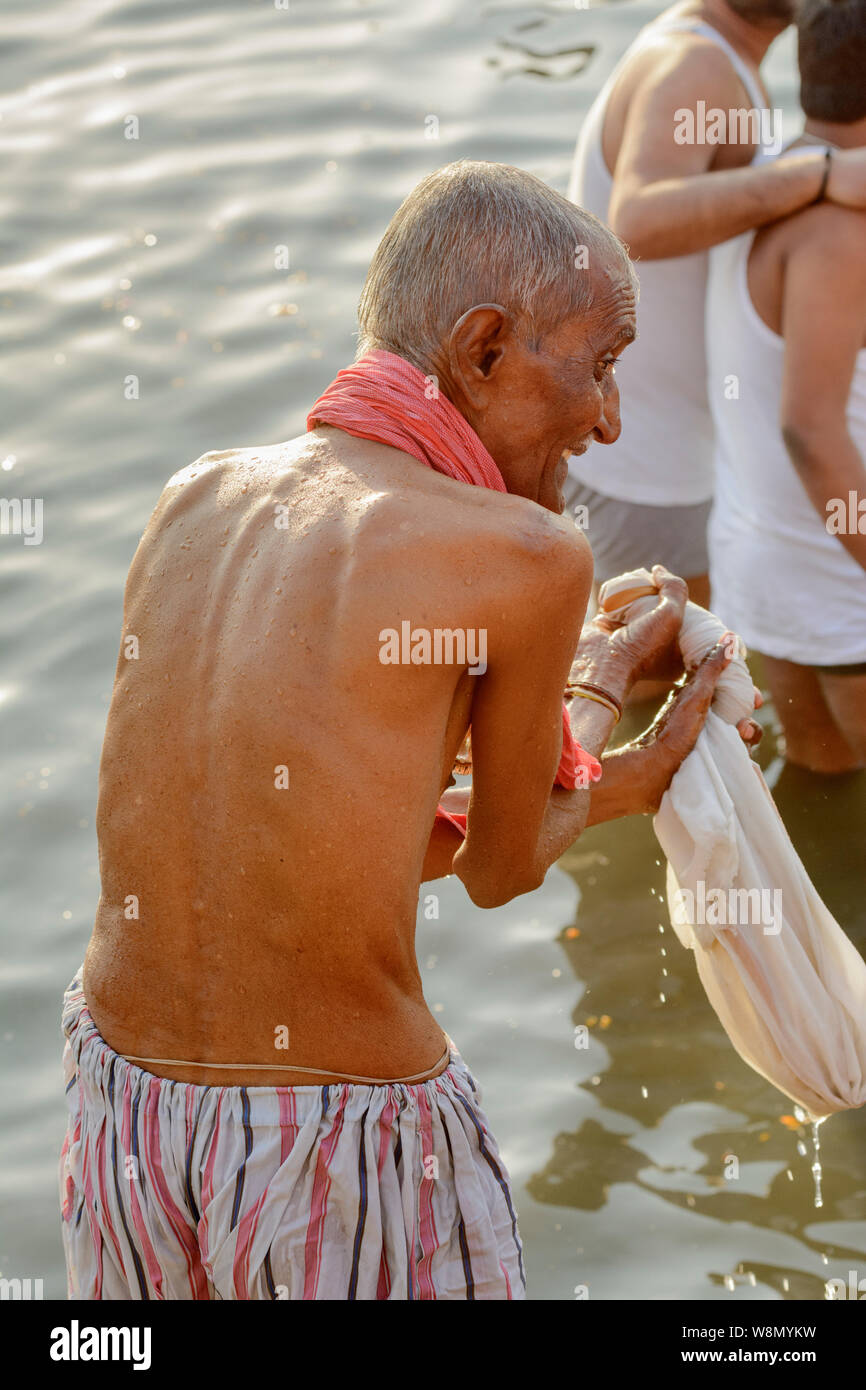 Eine ältere indisch-hinduistischen Mann mit einem Lungi führt am frühen Morgen Baden Ritual in den Fluss Ganges, Varanasi, Uttar Pradesh, Indien, Südasien. Stockfoto