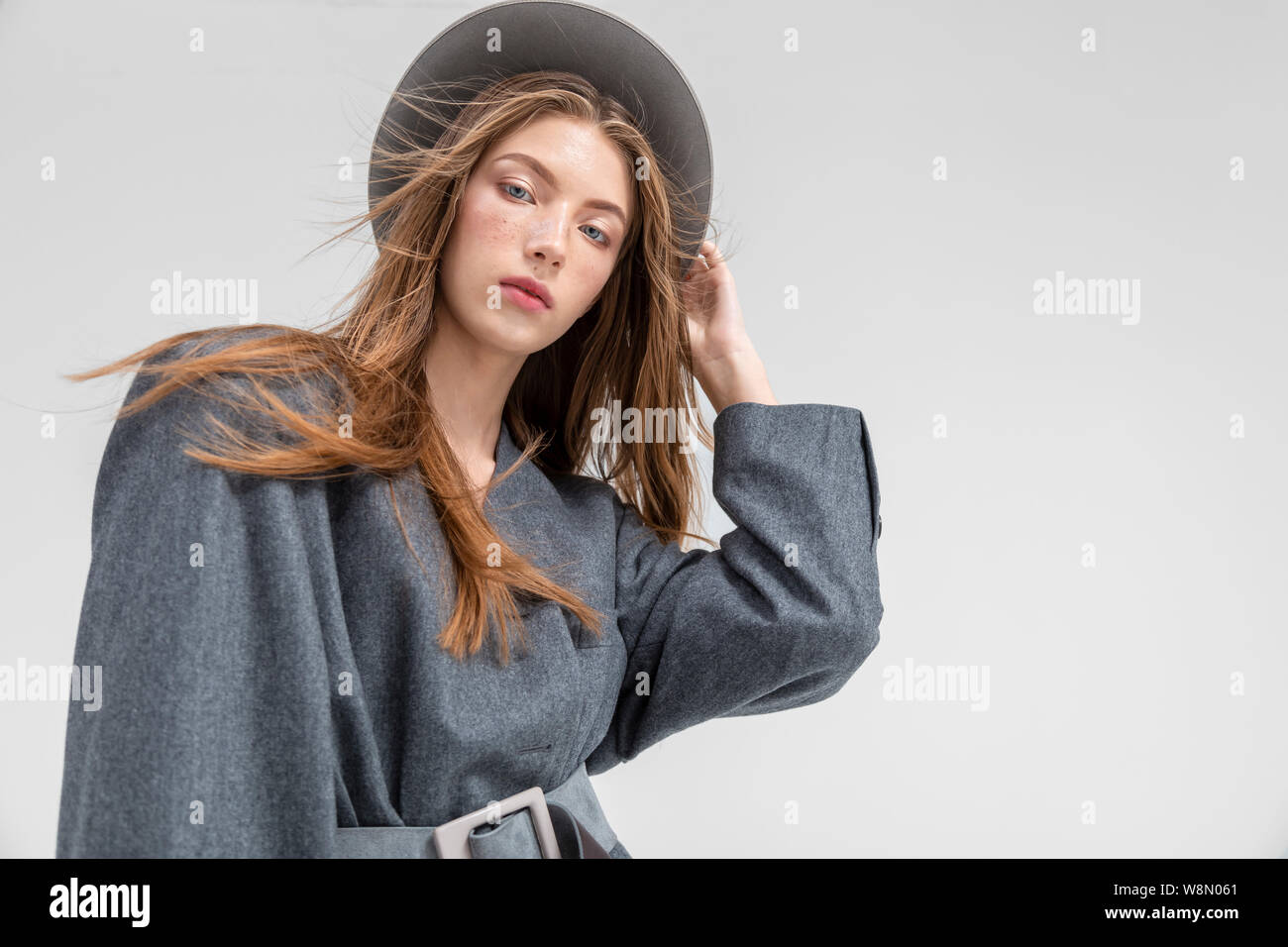 Portrait von stilvollen Modell in grau Outfit auf Kamera Low Angle View copyspace isoliert Stockfoto
