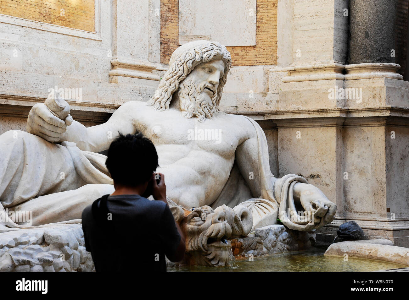 Marphurius oder Marforio sprechen Statuen von Rom mit einem asiatischen Besucher ein Foto. Rom, Italien Stockfoto