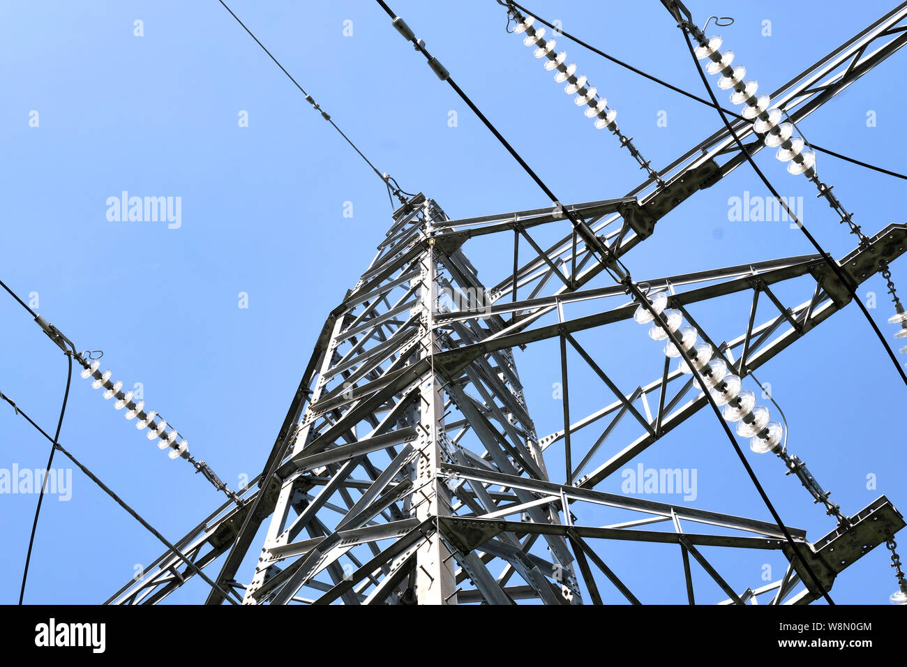 Ein metall National Grid electric power Kabel Turm Schuß gegen ein strahlend blauer Himmel Stockfoto