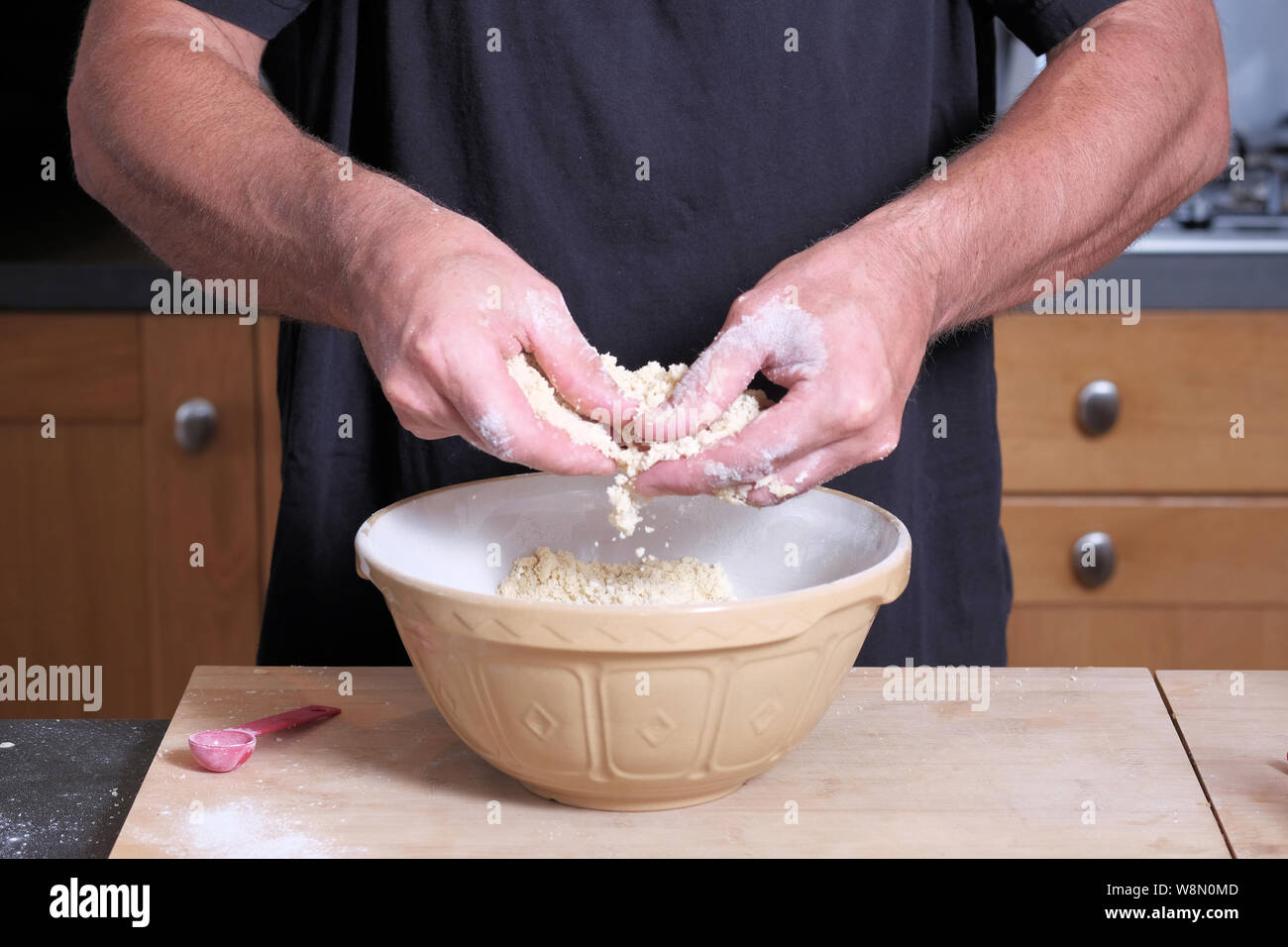 Eine männliche Koch oder Bäcker mischen Kuchenteig in einem Kuchen Schüssel Stockfoto
