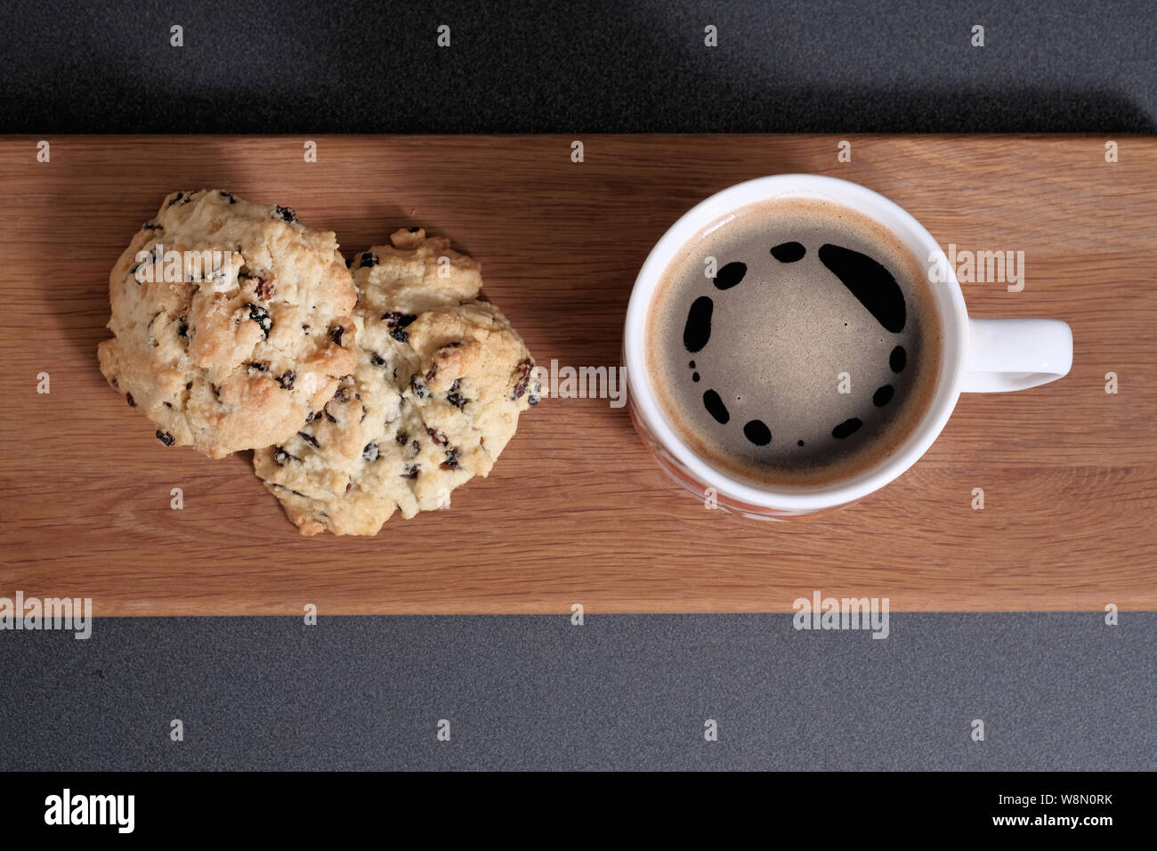 Zwei frisch zubereitete, traditionelle englische Steinkuchen, serviert mit einer Tasse schwarzem Kaffee Stockfoto