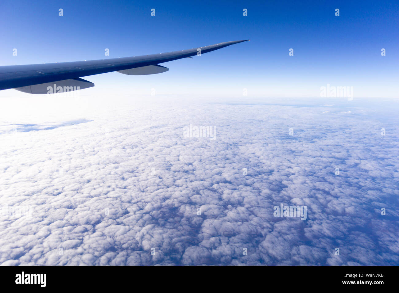 Im Flug Flugzeug Flügel durch das Fenster oben flauschigen weissen Wolken und Blau skycloud Stockfoto