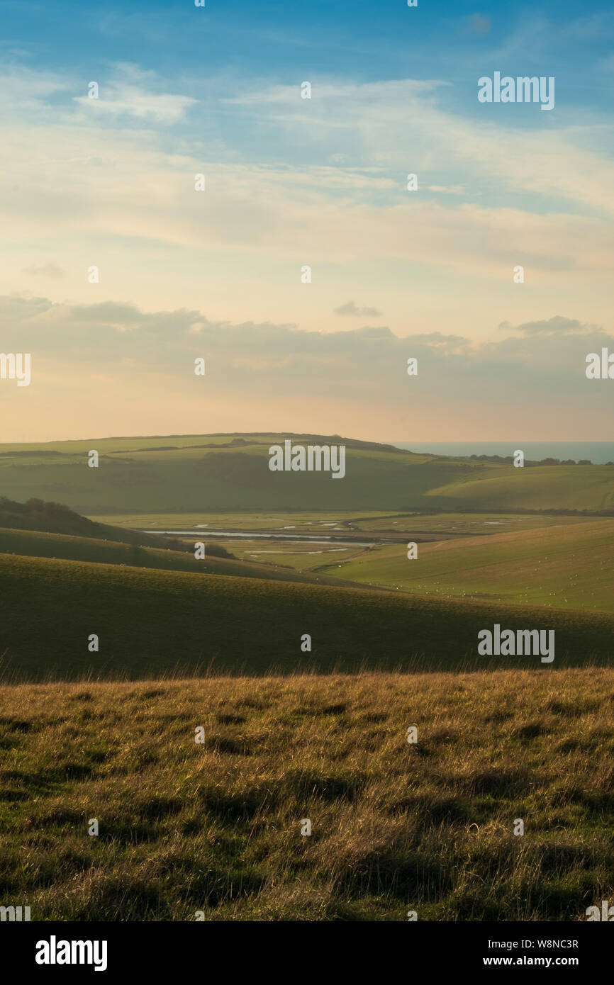 Auf der Suche über sanfte Hügel mit dem cuckmere Valley und Seaford in warmes Abendlicht 1. Stockfoto