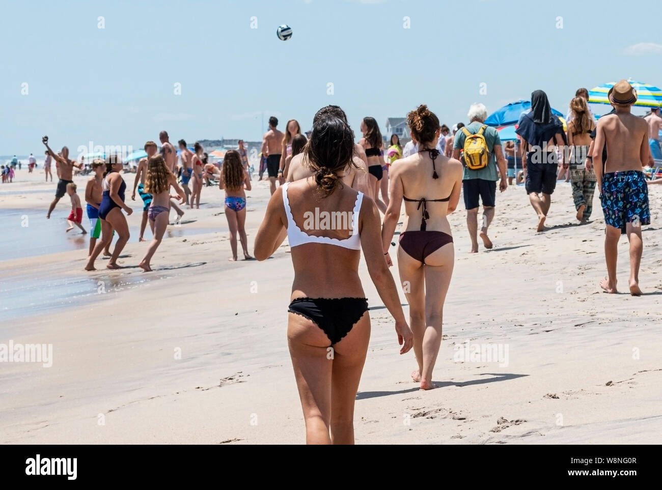 Viele Leute auf dem Wasser von einem Strand, Wandern, Ball spielen und Spaß am Memorial Day auf dem long island Küste. Stockfoto