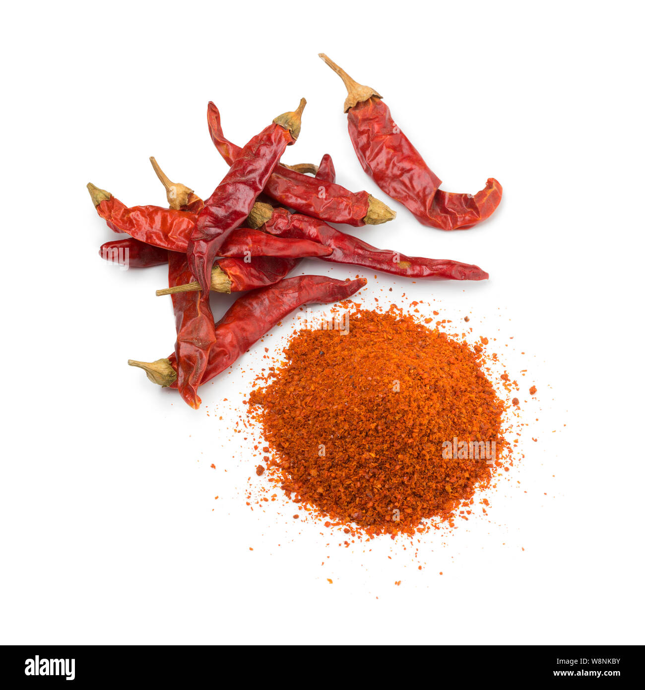 Haufen getrocknete rote Chilischoten und einem Haufen Chilipulver auf weißem Hintergrund Stockfoto