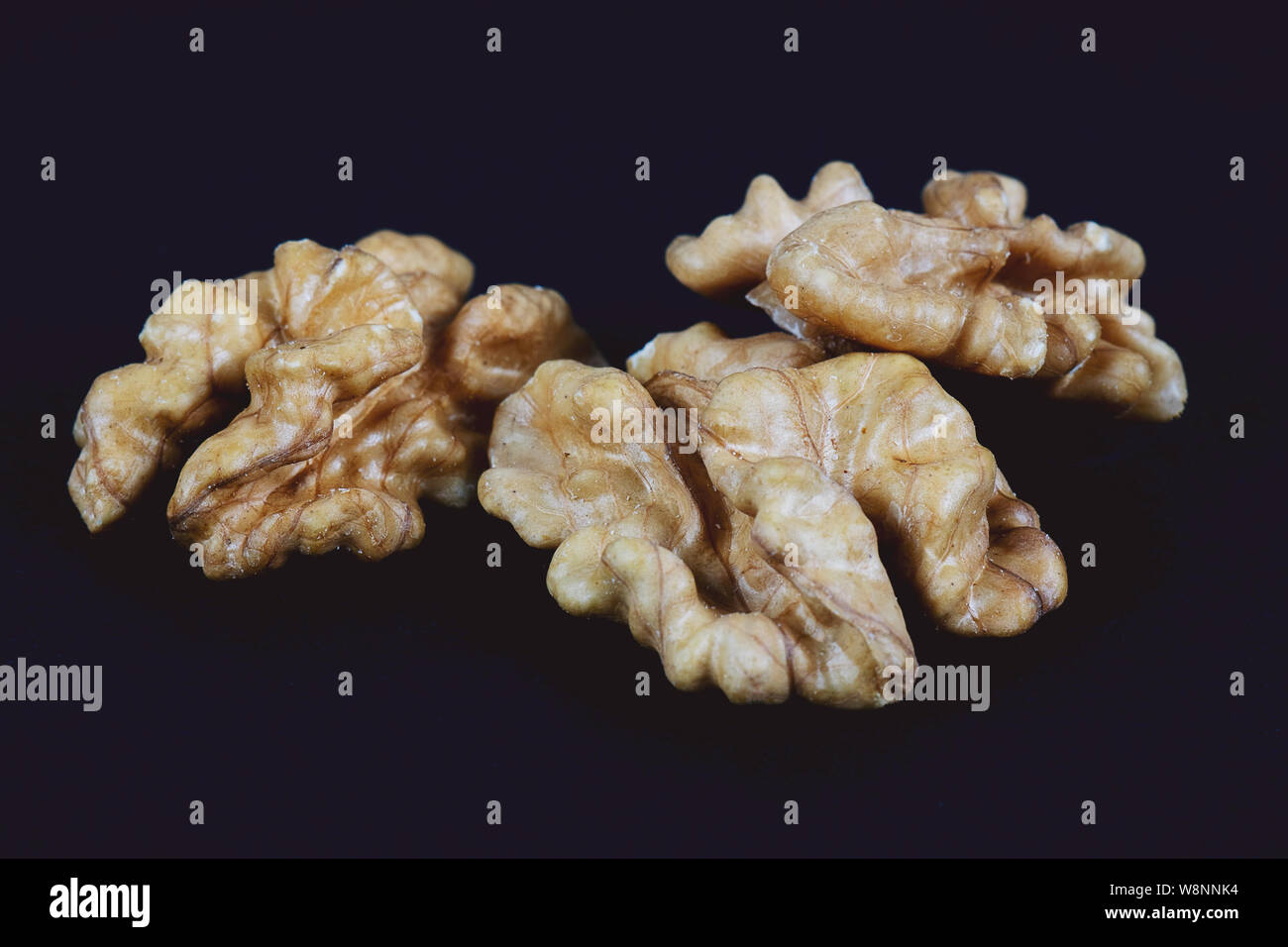 Walnüsse auf schwarzem Hintergrund. Stapel der Walnüsse ohne Schale closeup für ihr Design und Drucken. Muttern Sammlung Stockfoto