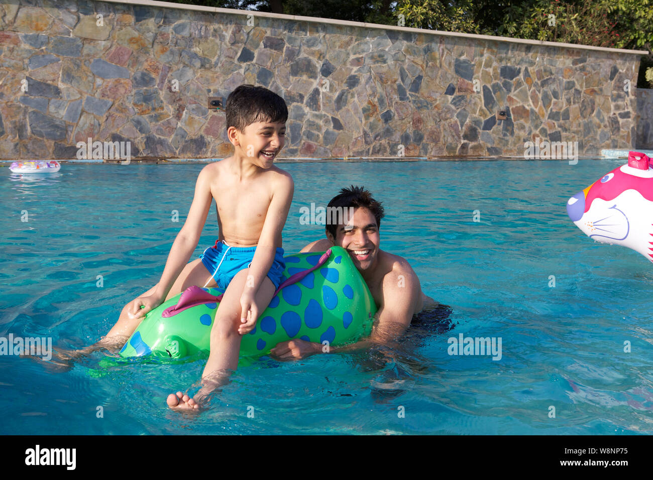 Vater und Sohn spielt in einem Schwimmbad Stockfoto