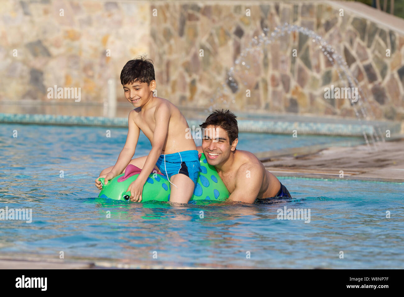 Vater und Sohn spielt in einem Schwimmbad Stockfoto