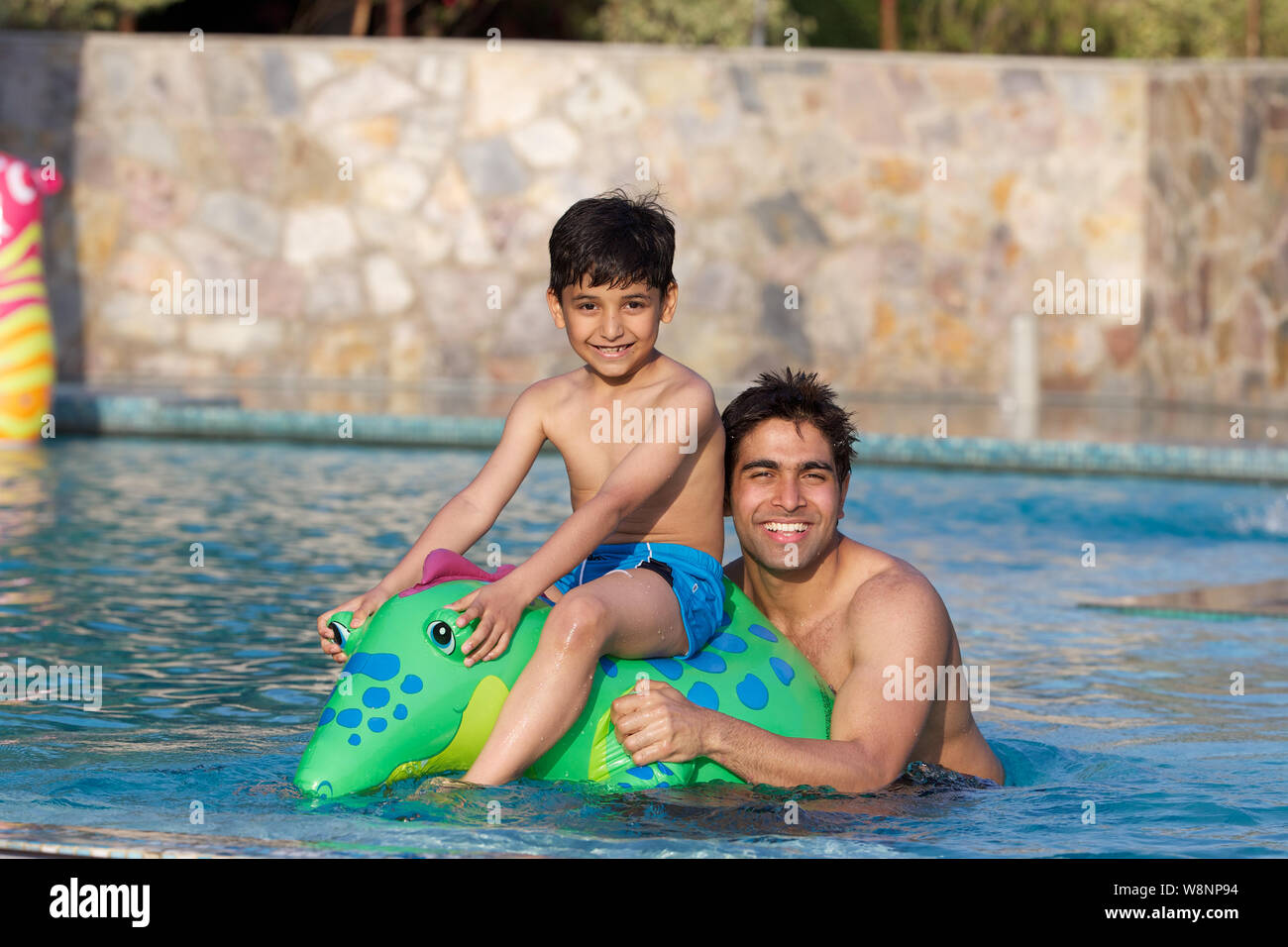 Vater und Sohn spielt in einem Schwimmbad Stockfoto