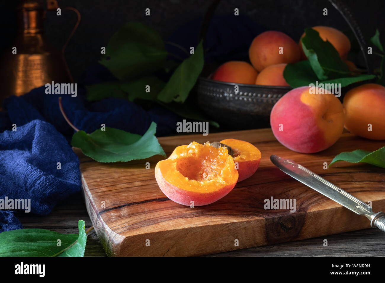 Frische reife Aprikosen auf einem Tisch - dunkle Fotografie Stockfoto