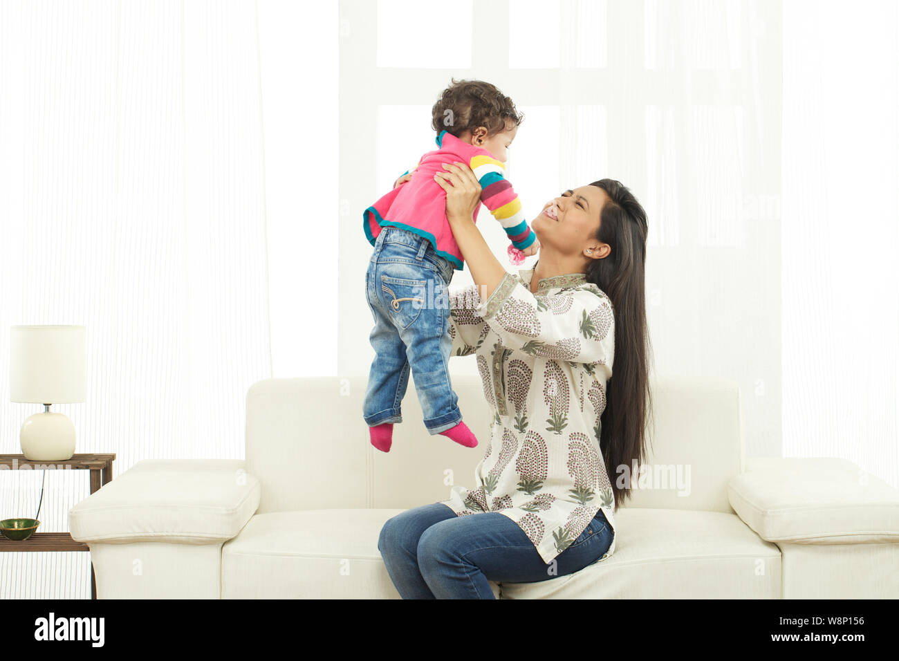 Mutter leidet unter Schmerzen im unteren Rücken beim Aufnehmen des Babys Stockfoto