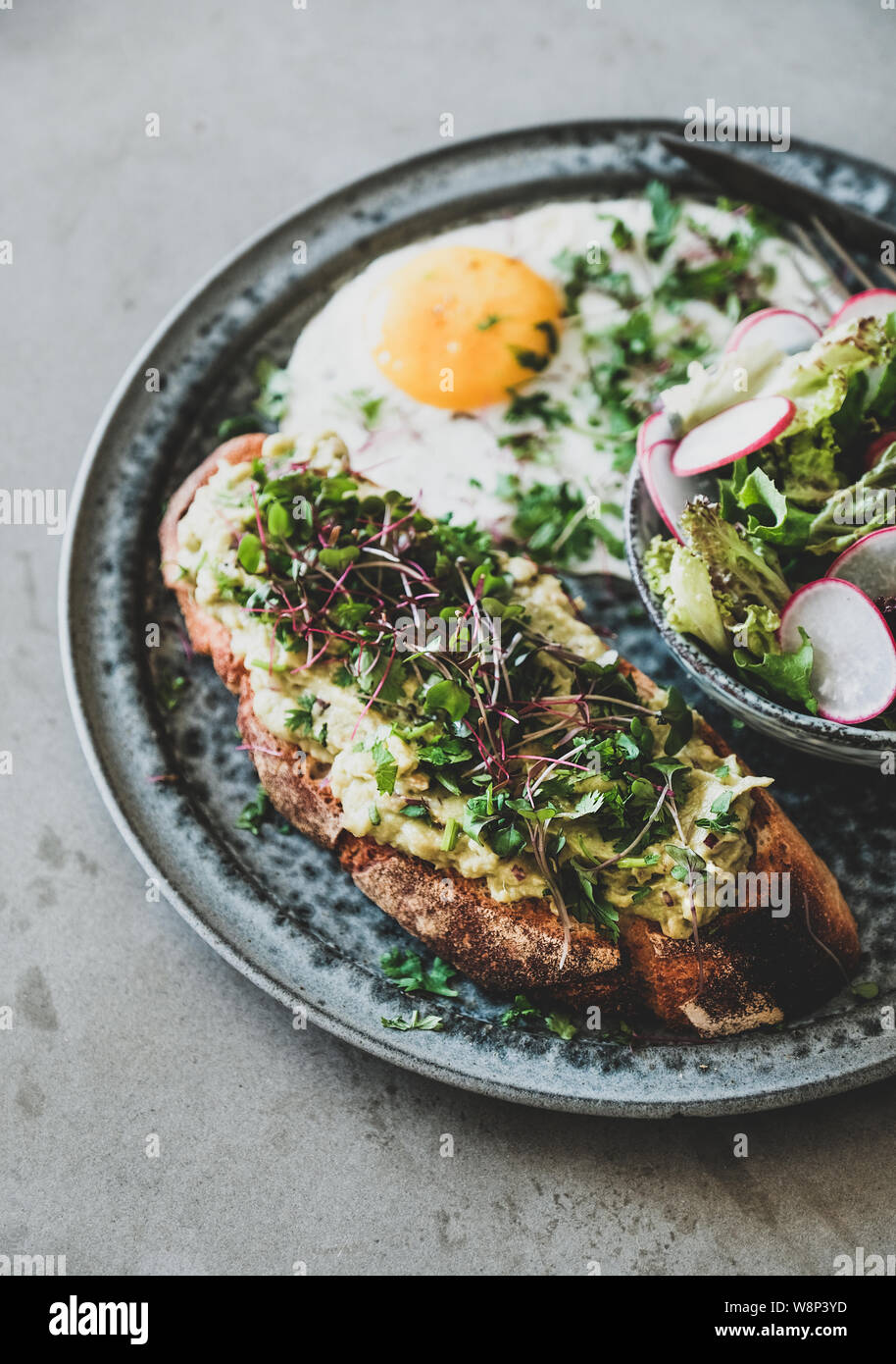 Avocado Toast, Spiegelei und Salat mit Radieschen Stockfoto