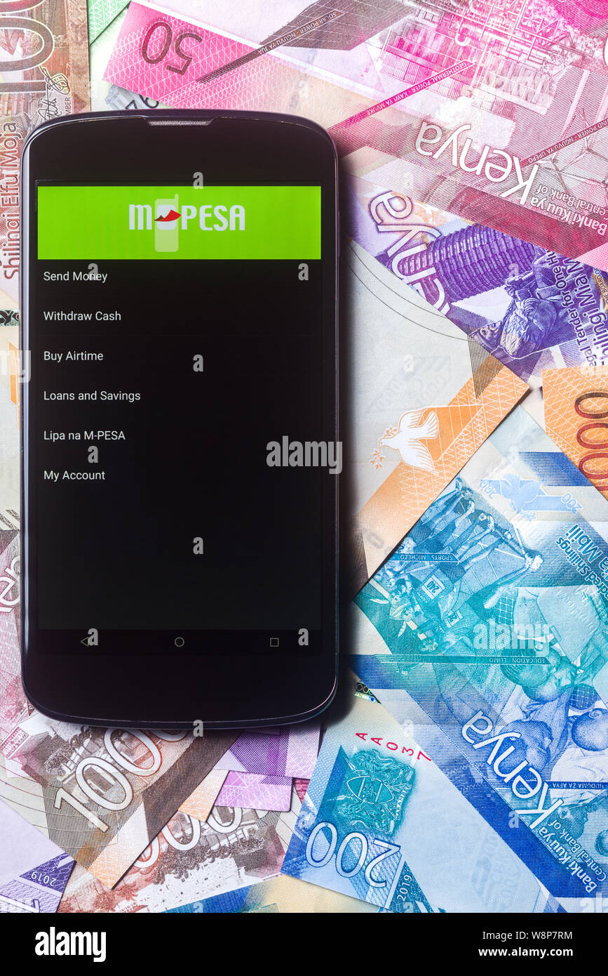 Safaricom M-Pesa fintech Mikrofinanz geld Transaction Service am Telefon mit neuen kenianischen Schilling Banknoten Hintergrund Stockfoto