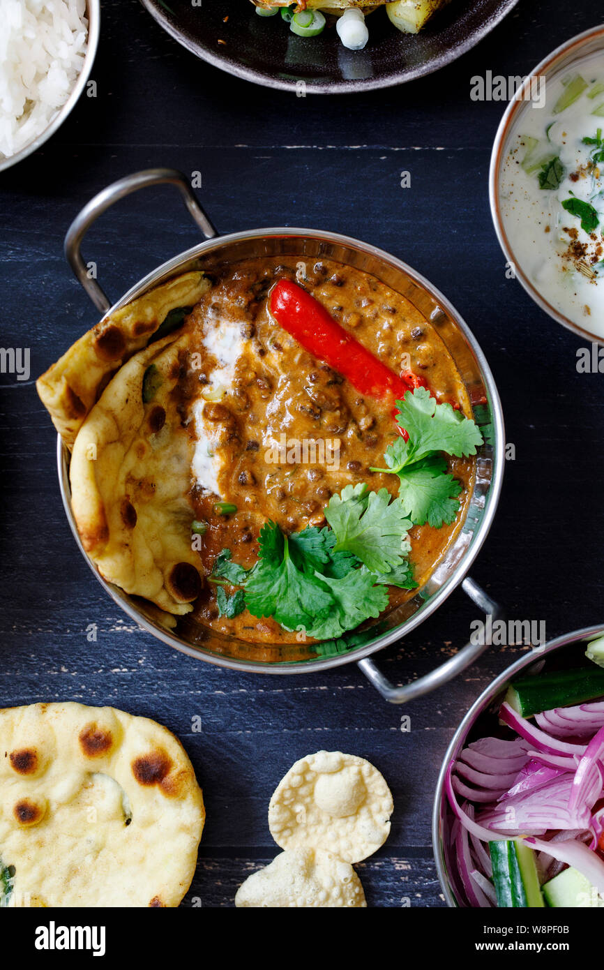 Indisches essen Curry mit schwarzen Linsen dal, Salat, Naan Brot und raita Stockfoto