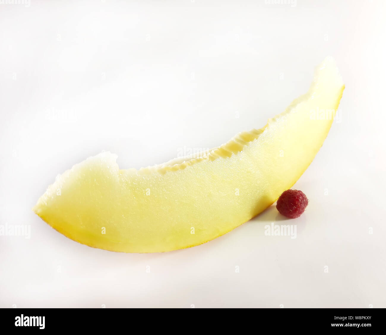 Rote Himbeeren und gelbe Melone, weisser Hintergrund. Vegetarisch, Diät Lebensmittel Stockfoto