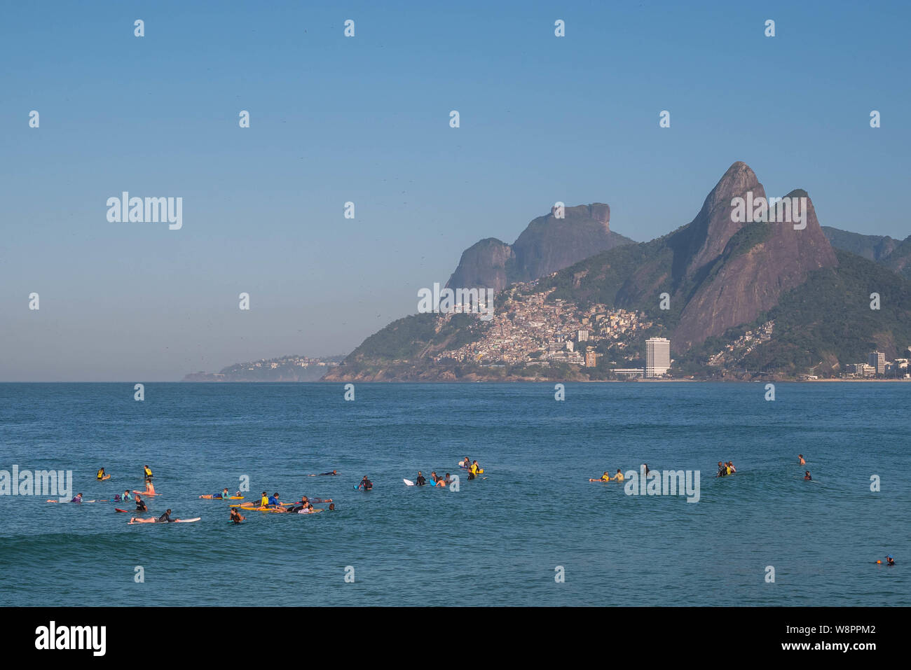 Rio de Janeiro, Brasilien - 10. August 2019: Arpoador, Ipanema Strand mit amateur Surfer warten auf Wellen auf das blaue Wasser und Berge als Backgr Stockfoto