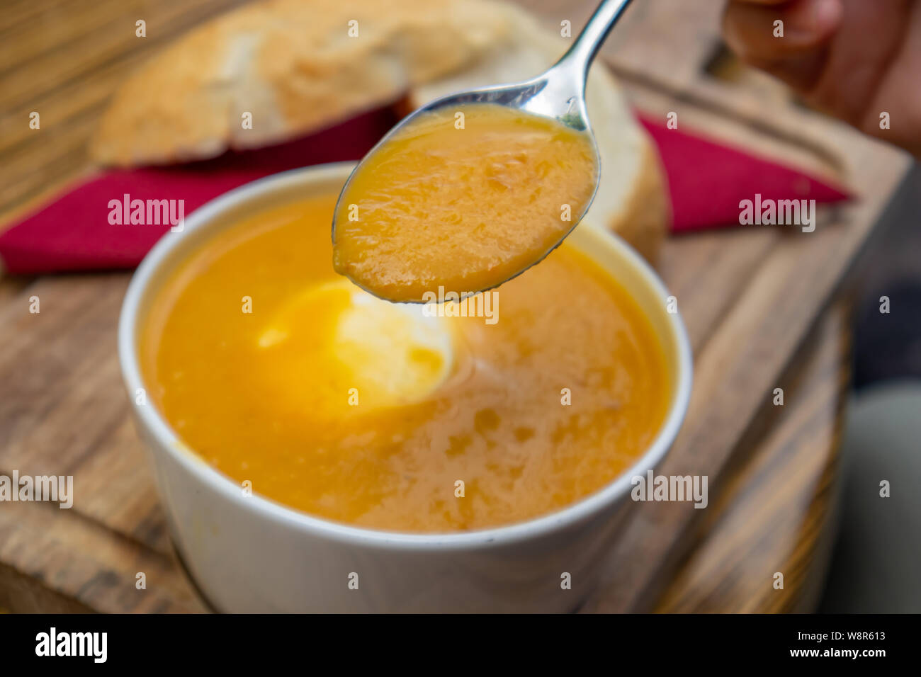 Kürbissuppe. Löffel mit Suppe Detailansicht, blur Tabelle Einstellen des Hintergrunds Stockfoto