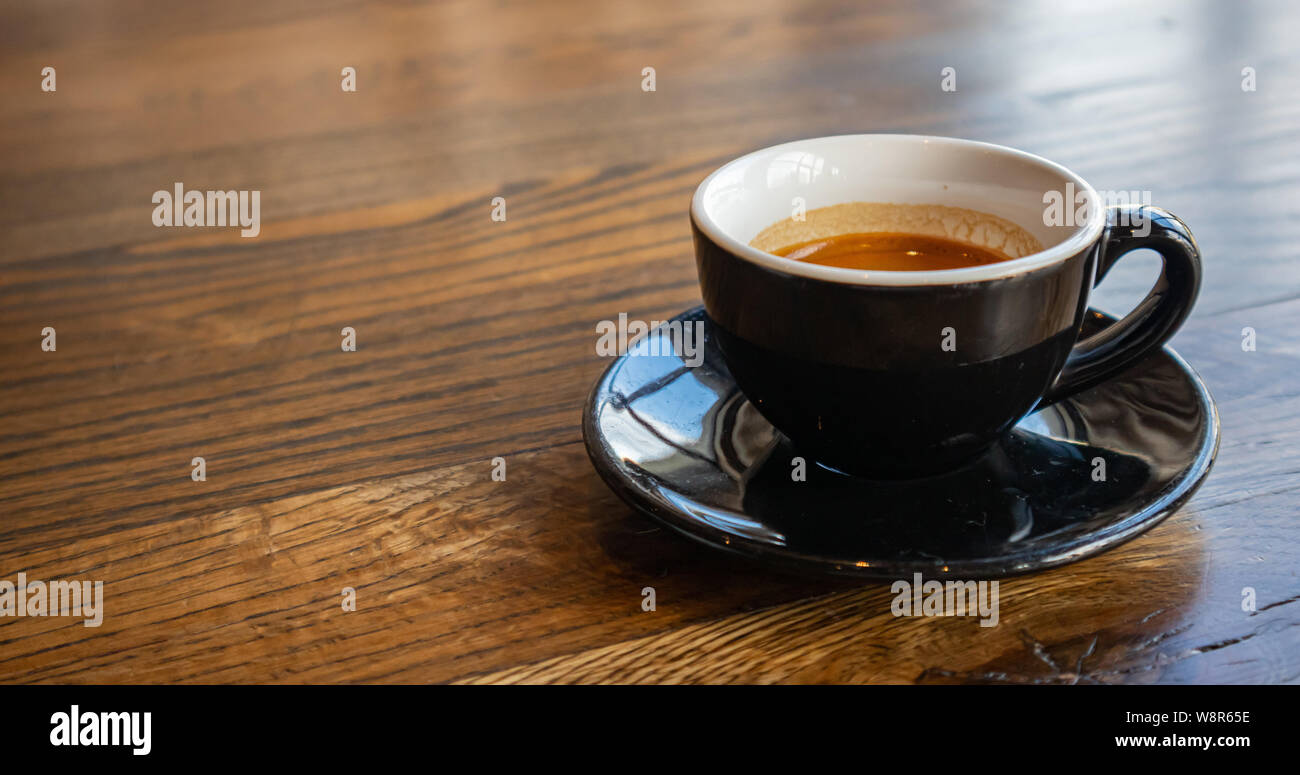 Espresso auf Holz. Espresso Tasse mit Untertasse, Schwarz Farbe auf Holz- Tabelle, kopieren Raum Stockfoto
