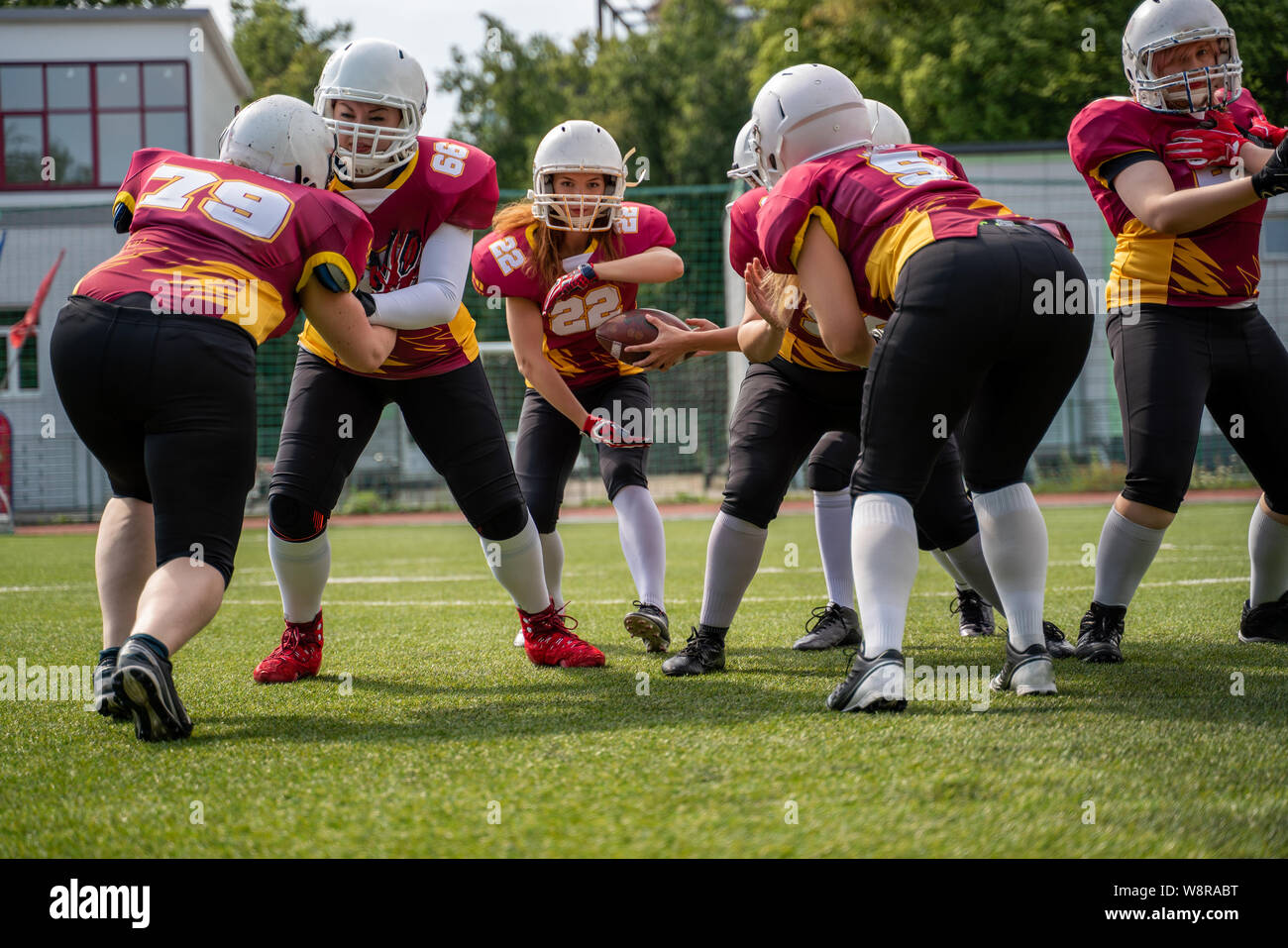 In voller Länge Foto von Sportlerinnen spielen American Football auf grünen Rasen Stockfoto