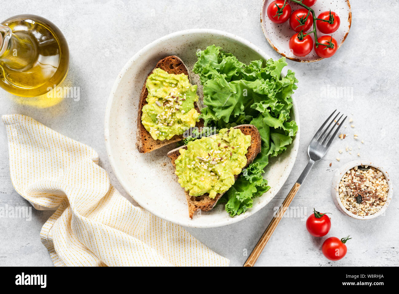 Gesund Vegan Avocado Toast und Kohl Salat mit Olivenöl an der Platte. Tabelle Ansicht von Oben. Sauber Essen Konzept Stockfoto