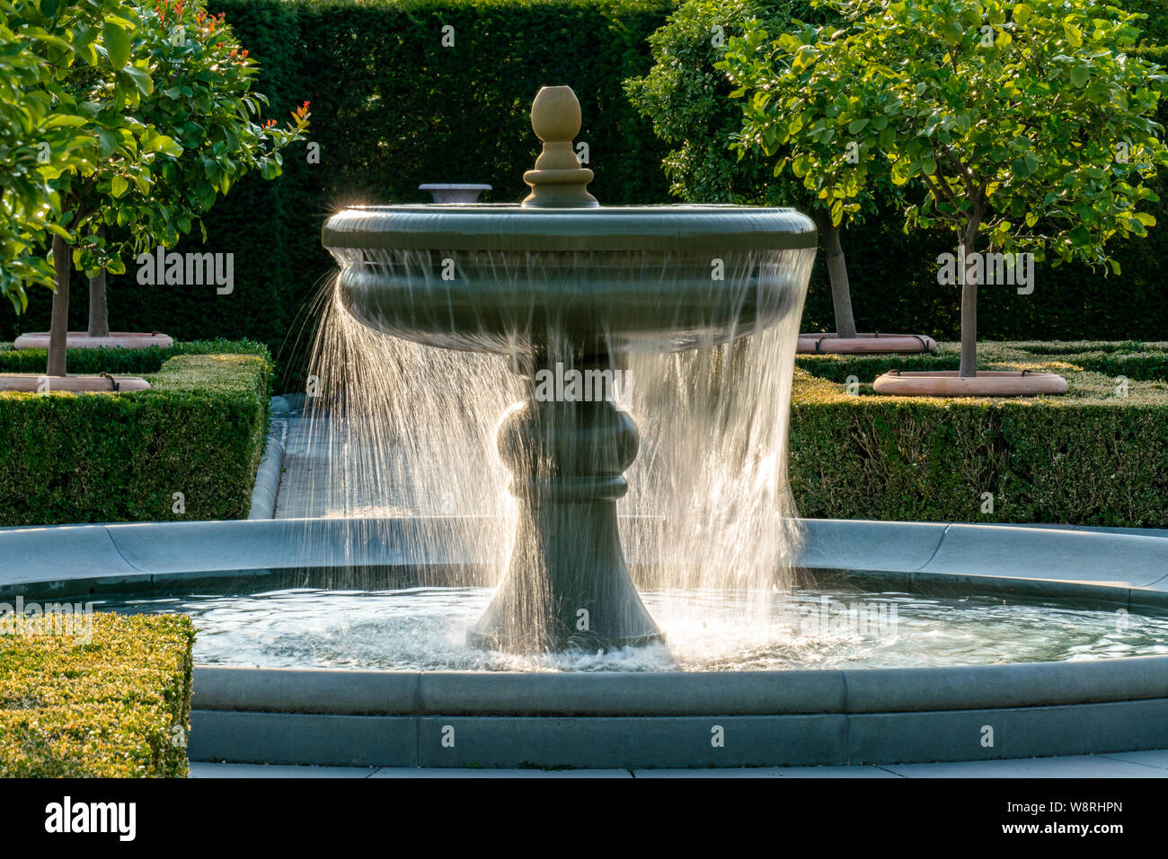Mit Wasser aus einem Brunnen mit detaillierten Wassertropfen glinstering im hellen Sonnenschein Stockfoto