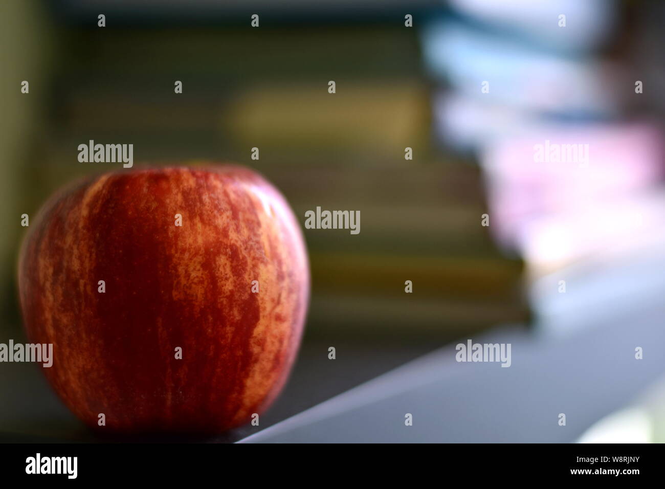 Zurück zu Schule Konzept Hintergrund. Red Apple vor unscharfen Stapel von Büchern. Selektiver Fokus, kopieren Raum Stockfoto