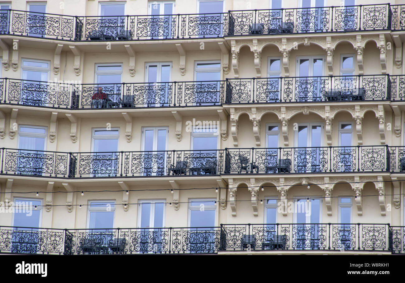 Brighton, Großbritannien, 19. Juli 2019 -: Balkone von großes Hotel mit einsamen Mann Stockfoto