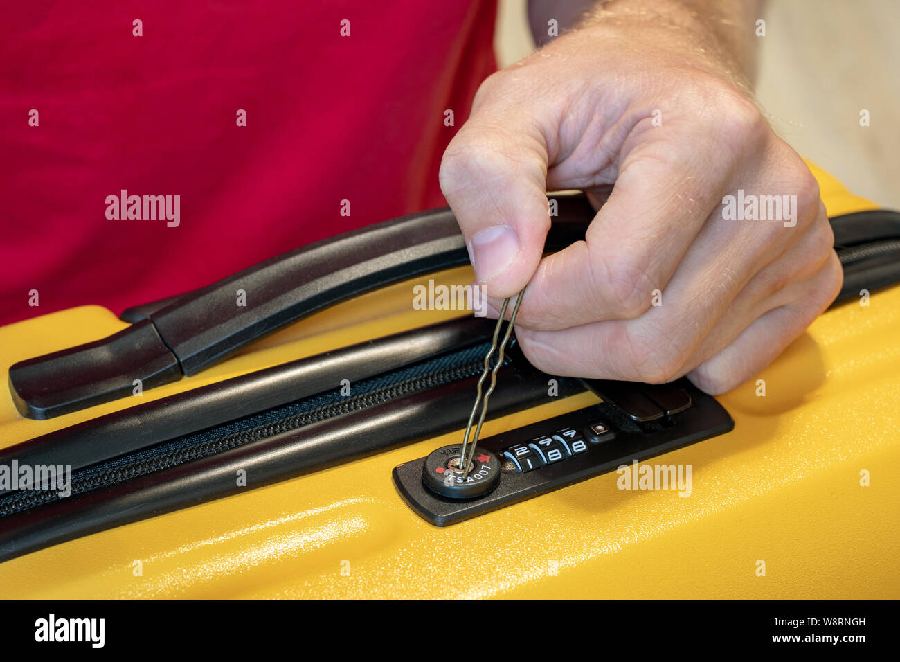 Passwort Code oder Chiffre. Ein Mann öffnet ein Koffer mit Zahlenschloss, hält eine Haarnadel in seinen Händen. Stockfoto